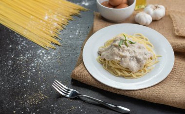 Ahşap masa arka plan üzerinde beyaz plaka spagetti cabonara.