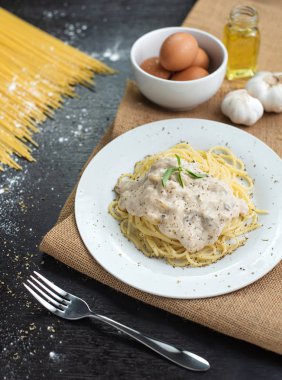 Ahşap masa arka plan üzerinde beyaz plaka spagetti cabonara.