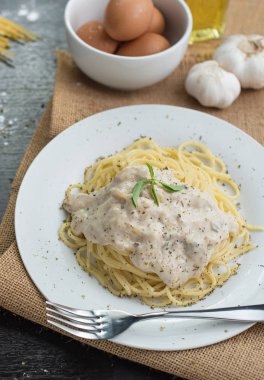 Ahşap masa arka plan üzerinde beyaz plaka spagetti cabonara.