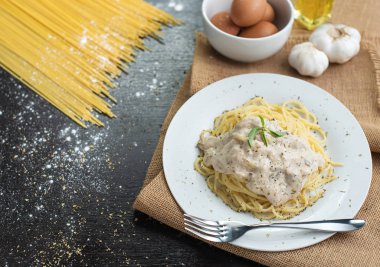 Ahşap masa arka plan üzerinde beyaz plaka spagetti cabonara.