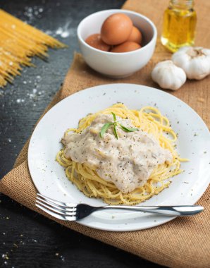 Ahşap masa arka plan üzerinde beyaz plaka spagetti cabonara.