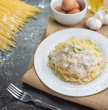 Ahşap masa arka plan üzerinde beyaz plaka spagetti cabonara.