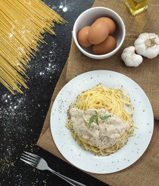 Ahşap masa arka plan üzerinde beyaz plaka spagetti cabonara, üst görünümü