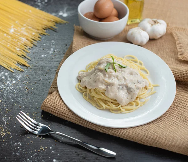 Ahşap masa arka plan üzerinde beyaz plaka spagetti cabonara.