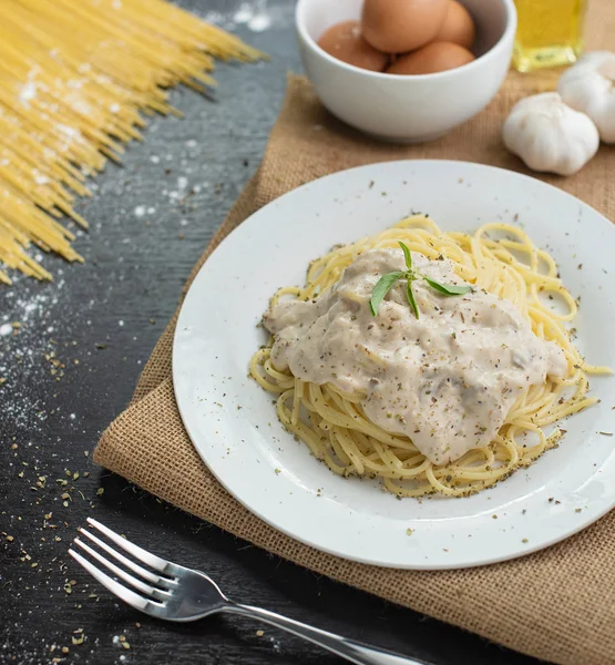 Ahşap masa arka plan üzerinde beyaz plaka spagetti cabonara.