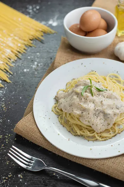 Ahşap masa arka plan üzerinde beyaz plaka spagetti cabonara.