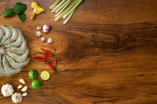 Färska råa räkor i en vit skål och matlagning ingredienser för Tom yum kung på trä bakgrund — Stockfoto