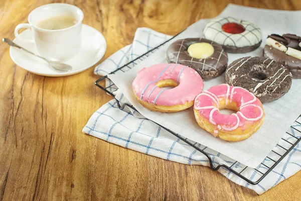 Пончики и кофе на деревянном столе . — стоковое фото