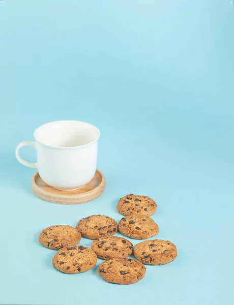 Galletas chips de chocolate y taza de café en el suelo, colores pastel azul claro — Foto de Stock