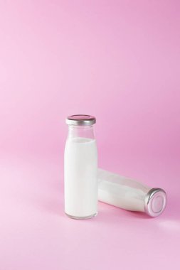 pembe arka planda süt şişe