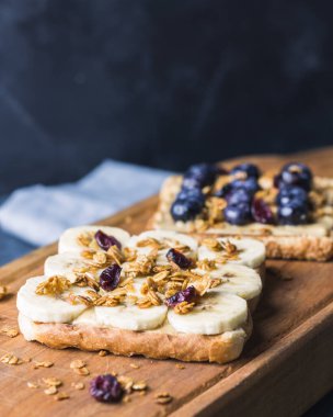Muzlu tatlı ekmek, fıstık ezmesi, yaban mersini ve granola. Sağlıklı gıda konsepti. Boşluğu kopyala.