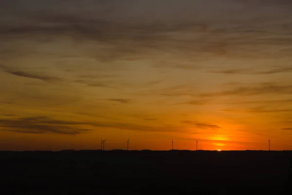 Beautiful sunset between wind turbines on the horizon — Stock Photo, Image