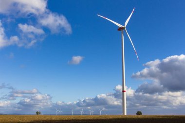 Rüzgâr türbini bulutlu mavi gökyüzünden önce