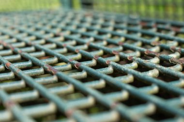 Boyanın soyulduğu, seçilmiş odak noktası olan yeşil metal park bank ızgarasının eğimli görüntüsü