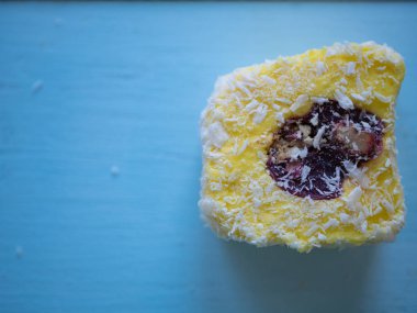 mavi ahşap arka plan üzerinde içinde kırmızı fıstıklı sarı Türk lokumu. ateş en iyi görünümü kapatın