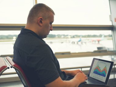 yan Havaalanı terminal kalkış bölgede çalışan erkeğin bir kadeh. sunu iş grafik girişimci gezisi için yapma. Dijital göçebe yaşam tarzı