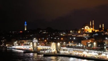 Doğal görünümü gece Istanbul Galata Köprüsü ile ve güzel backight ile Süleymaniye Camii. Feribot yelken Haliç Körfez Köprüsü altında Galata Köprüsü üzerinde. 4 k video görüntüleri