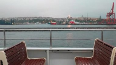 Feribot Tekne Boğaz manzaralı iki boş sandalye ve liman, vinçler ile yelken