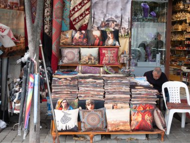 Istanbul, Türkiye - 26 Eylül 2018: satıcı küçük Hediyelik Dükkanı otantik Türk yastıklar, minder, yastık kılıfları süslemeli, desenleri ile Istanbul caddesinde oturur adam