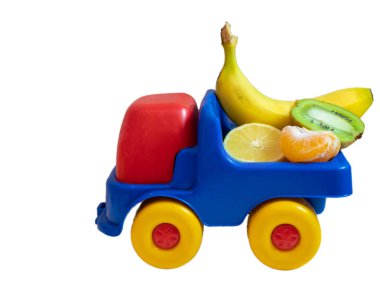 muz, kivi, mandarine, limon - oyuncak araba kamyon üzerinde egzotik meyve. ogranic gıda teslim hizmet anlayışı. yan izole üzerinde beyaz arka plan vurdu