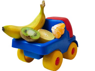 muz, kivi, mandarine, limon - oyuncak araba kamyon üzerinde bazı egzotik meyveler. ogranic gıda teslim hizmet anlayışı. arkasından arka izole üzerinde beyaz arka plan vurdu