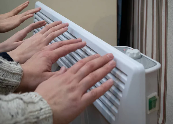 Aile üç kişinin kış sezonu ev elektrikli ısıtıcı ısınıyor. Ev Maliye Bütçe yardımcı programı faturaları kavramı. portre vurdu