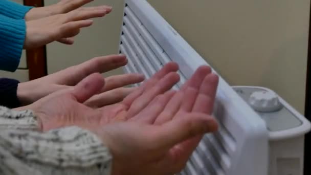 Drei Paar menschliche Hände, die sich in der kalten Winterzeit zu Hause erwärmen. Home Finance Budget hohe europäische Versorgungsrechnungen Konzept. Nahaufnahme statisches 4k Filmmaterial