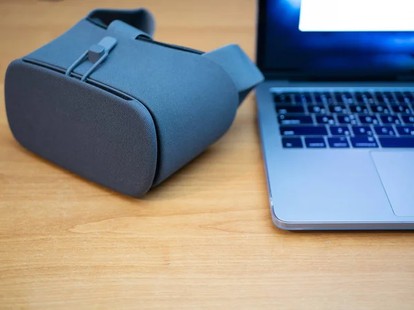 close-up of VR goggles next to laptop for virtual reality experience or software development for augmented reality features