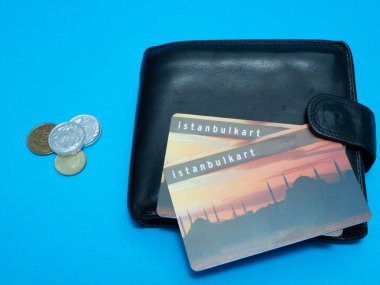 Istanbulkart ulaşım Istanbul plastik kart ve Türk Lirası para üzerinde mavi arka plan ile siyah cüzdan