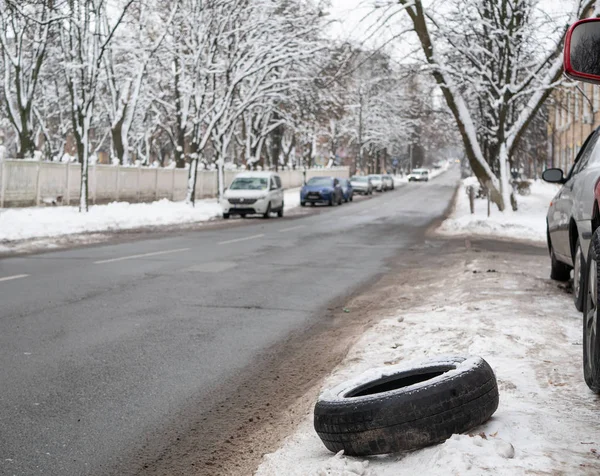 路边坏了的汽车轮胎 选择性地聚焦在轮胎 背景街道与汽车模糊 户外冬季拍摄 — 图库照片