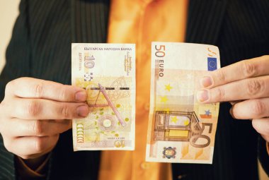işadamı kıyafetli bir yandan ve 50 Bulgar levs banknot para tutan diğer elinde 50 Euro. Bulgaristan schengen bölgesi onay closeup çekim tasvir