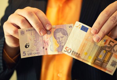 adam ellerini closeup diğer elinde bir ve 50 Euro Romence lei para göster. Romanya tümleştirme için Avrupa Birliği AB kavramı