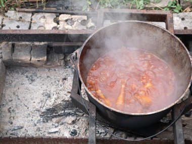 açık hava üzerinde kaynar pişmiş sebze et güveç ile büyük ağır kazan. Yaz açık görüntü yukarıda görüntüleyin. kimse çerçeve içinde