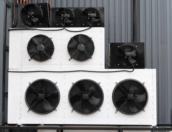 closeup photo of wall filled with rows of industrial air conditioner unit HVAC climate control system with huge fans