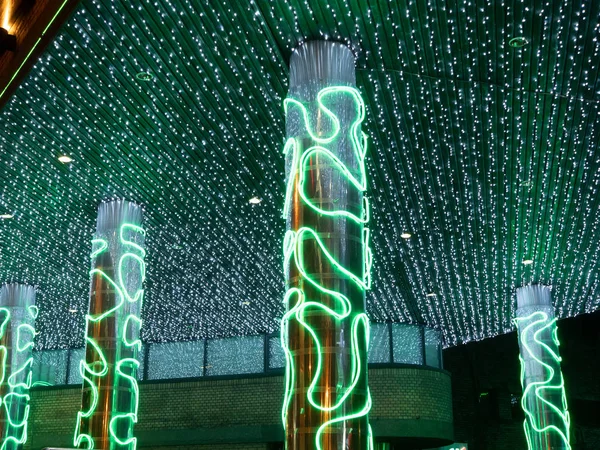 bright vivid green garland on city building at night. low key photo