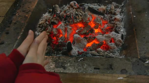 Primer plano manos calentando en el carbón ardiente — Vídeo de stock