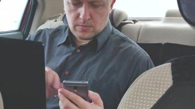 arka koltukta bir dizüstü bilgisayar ve akıllı telefon yapımı taksi araba adam arama. yakın çekim 4k video görüntüleri