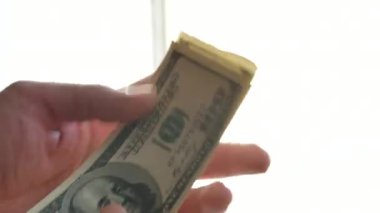 Beyaz adam koklama kokulu taze yüz banknot beyaz. makro yakın çekim video 4k görüntüleri ile beyaz arka plan yandı. ilk kazanılan para kavramı