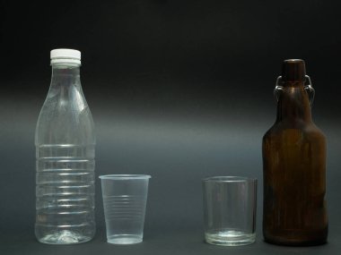 Plastik vs malzemeler şişe ve bardak siyah koyu arka plan üzerinde cam