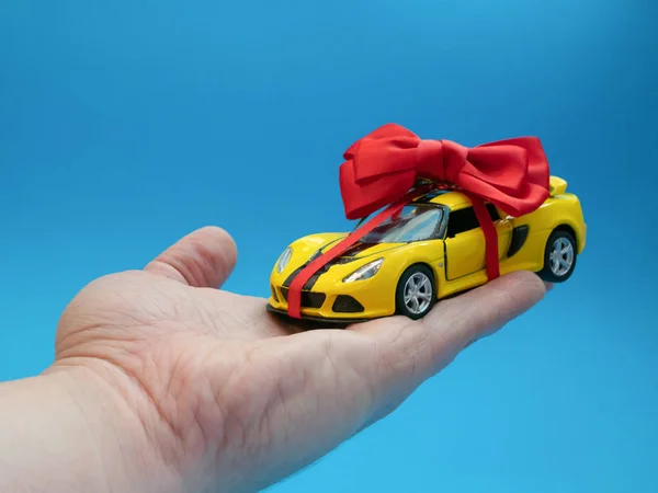 Kleines Gelbes Spielzeugauto Mit Roter Schleife Als Geschenk — Stockfoto