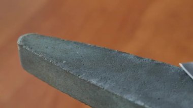 Makro yakın çekim Şef suşi bıçak değirmentaşı keskinleştirme. 4 k video görüntüleri ilmekledi