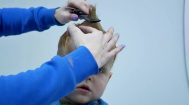 baş şirin 2 yıl yaşlı erkek çocuk üst makasla kesme saç. portre el 4k video