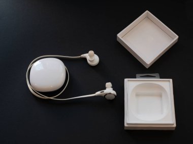 Kablosuz kulak içi kulaklıklar kulaklık siyah arka plan üzerine beyaz açılan kutusu. düşük anahtar görüntü