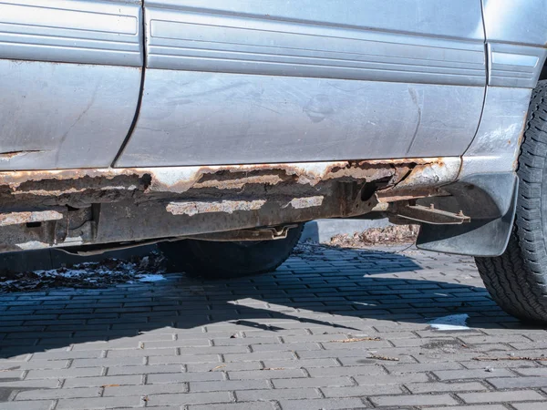Close-up do fundo do carro danificado por corrosão oxidação erosão. imagem dia ao ar livre. conceito de serviço anti corrosão do tratamento do veículo — Fotografia de Stock