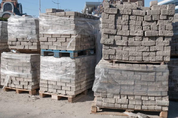 Entrepôt extérieur avec beaucoup de palettes pleines de briques pavées pierres — Photo