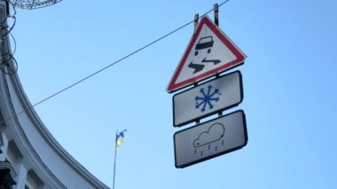 Tel sokak - karlı ya da Yağmurlu hava olduğunda kaygan yol altında sallayarak yol işaretleri. Ukrayna bayrağı istikrarsız siyasi durum kavram olarak arka plan üzerinde sallayarak. Zemin videodan görüntülemek