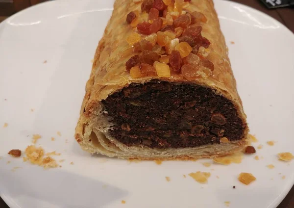 homemade poppy seeds layer cake with dried fruits on top. freshly baked dessert on white plate