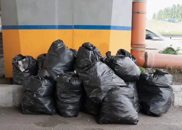 Tas de sacs poubelles noirs sur la rue de la ville — Photo