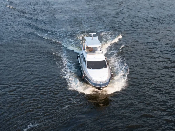 Aerial drone shot of small motorized white yacht sailing at the sea Stock Photo