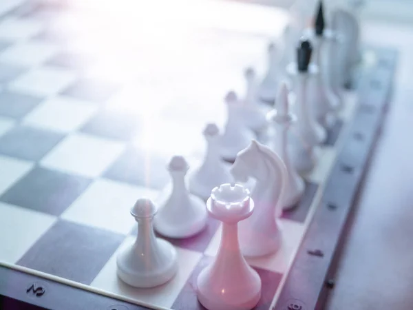 Šachovnici s bílými postavami. selektivní zaměření na nejbližší postavu a únik světla shora — Stock fotografie